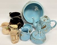Full group shot of all ceramic items including the teapot, serving bowl, sugar bowls, and creamers