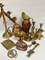 Full lot showing assorted vintage copper and brass items including altar candelabra, pitchers, and candlesticks