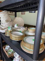 Shelving with stacks of plates, bowls, cups and storage cases