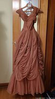 Front view of formal orange chiffon dress showing ruffled skirt and pleated off-shoulder straps