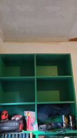 Shelf unit holding various tools including boxed Skil jigsaw, Black & Decker mouse sander, and Ryobi saw case.