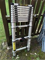 Collapsed ladder against fence