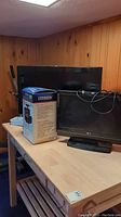 Photo showing LG and Samsung TVs side by side on table along with boxed Citizen 5-inch portable TV
