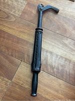 Full view of antique industrial nail puller showing overall shape and handle design.