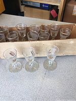 Set of 12 small sorbet or shot glasses in a cardboard holder, showing the gold leaf leaf and frosted band decoration.