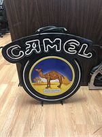 Front view of Camel neon light sign with illuminated 'CAMEL' text and camel logo in center.