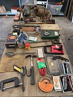 Overview of lot showing tools, decoys, fishing gear, camping stove, and various small items arranged on tables.