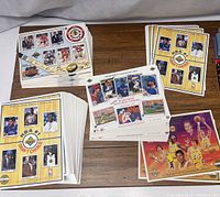 Full view of multiple stacks of Upper Deck 8x10 NBA and MLB numbered card sheets stacked on a table
