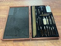 Closed wooden case opened to show cleaning rods and brushes neatly organized inside