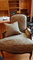 Chair angled front left view showing seat, armrest and toss pillow