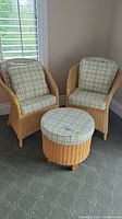 Front view of two wicker armchairs and ottoman with cushions