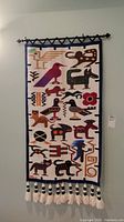 Full view of handwoven wall hanging hung on wall showing design and proportions