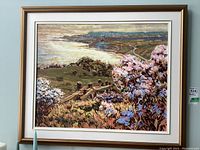 Framed painting front view showing coastal landscape scene with flowers and fence