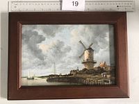 Front view of a Dutch print depicting a windmill and boats, framed in wood, with a ruler for size context.