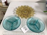 Photo showing amber-colored glass tidbit tray with plastic handle and two turquoise divided glass serving dishes on a white table with measuring ruler showing size of 8-11 inches.