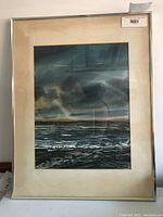 Framed watercolour painting by Michael Hitchcock depicting a moody, cloudy seascape or waterfront at sunset, shown in a silver frame with beige yellowed matting.