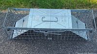 Front top view of rectangular metal wire animal trap with metal panel and carrying handle