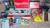 Full overview of classic game boxes including Monopoly, Aggravation, Spill and Spell, Uno cards, and peg game components.