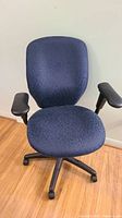 Front angled view of blue office chair showing seat, backrest, armrests and base