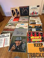 Full view of all 26 vintage vinyl LP records arranged standing and stacked, showing album art and titles from artists and themed collections including Sinatra, Ray Conniff, The Four Lads, and trucking and sound effect records.