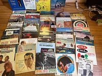 Multiple vintage vinyl LP records arranged on a floor, showing variety and quantity of 56 records.