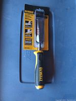 Full view of Dewalt construction chisel in packaging with visible blade and handle.