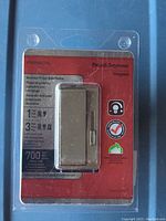 Photo of Legrand slide dimmer in original sealed packaging showing front view and product details.