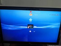 Photo of the LG monitor displaying the PlayStation 3 login screen, showing the console is powered on and working.