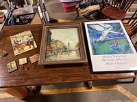 Top view of entire collection showing three framed pieces and three decorative hooks on wooden table