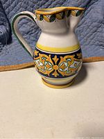 Full view of the handpainted Italian ceramic pitcher showing detailed paintwork and handle