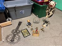 Overall view of lot items including pig figurine, guitar wall art, teddy bear, brass dancing ladies, brass insects, and cage accessory.