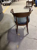 Rear view of the Mid Century Modern chair showing curved wooden backrest and legs with worn finish.