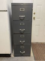 Front view of the four drawer vertical steel filing cabinet showing the exterior, handles, and label holders on each drawer.