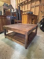 Side angle view of wooden coffee table showing carved edge detail and lower slatted shelf