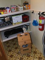 Shelf with bakeware items, boxes, and red baking pot