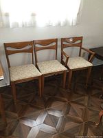 Front view of three chairs including armchair on right