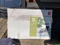 Box showing graphic of black Zero Gravity Lounge Chair with adjustable canopy outdoors