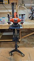 Full view of Black & Decker bench grinder on rolling stand in workshop environment.