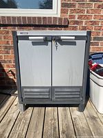 Front view of the Husky outdoor cabinet showing two doors with lock and key attached.