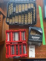 Overview of three drill bit sets: large compartmentalized black case with assorted metal drill bits, red case with multiple screwdriver bits, and a black Mastercraft titanium-coated drill bit set.