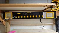 Prime branded lighted power strip mounted on wood, featuring 8 outlets and LED lights on each end.
