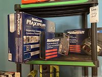 Photo of three boxed items on a chair set: Inspection camera, digital multimeter kit, and laser level kit, all Mastercraft brand.