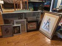 Group photo of multiple framed items and two boxed collage frames, showing variety of frames and prints included in the lot.