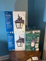 Three boxes of Altair Outdoor Energy Saving LED Lanterns stacked showing packaging and branding