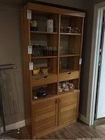 Front view of pine bookcase showing two sections of shelves, two drawers, and closed lower cabinet doors with visible wood grain finish.