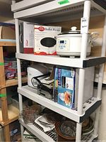 Photo showing one white plastic utility shelf loaded with kitchen appliances and cookware items (not included in sale). Shelf is white plastic slatted style.