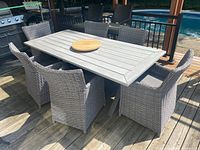 Full view of table and six chairs on deck under pergola