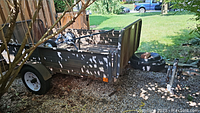 Side view of trailer on gravel with spare tires visible