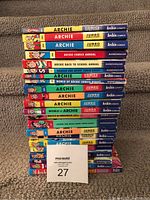 Front view of stack of 22 Archie comics showing colorful spines and titles, including Junior Jumble, Annuals and World of Archie