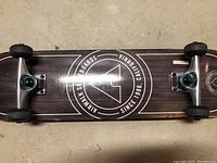 Top side of skateboard showing Airwalk logo on a dark wood finish with silver trucks and black wheels attached.